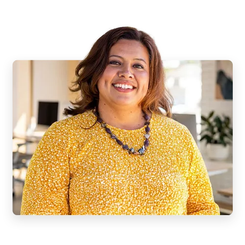 A smiling hispanic woman in a yellow sweater